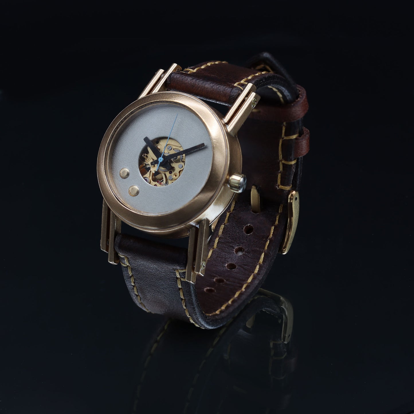 Retro futuristic wristwatch with brown leather strap and bronze casing.