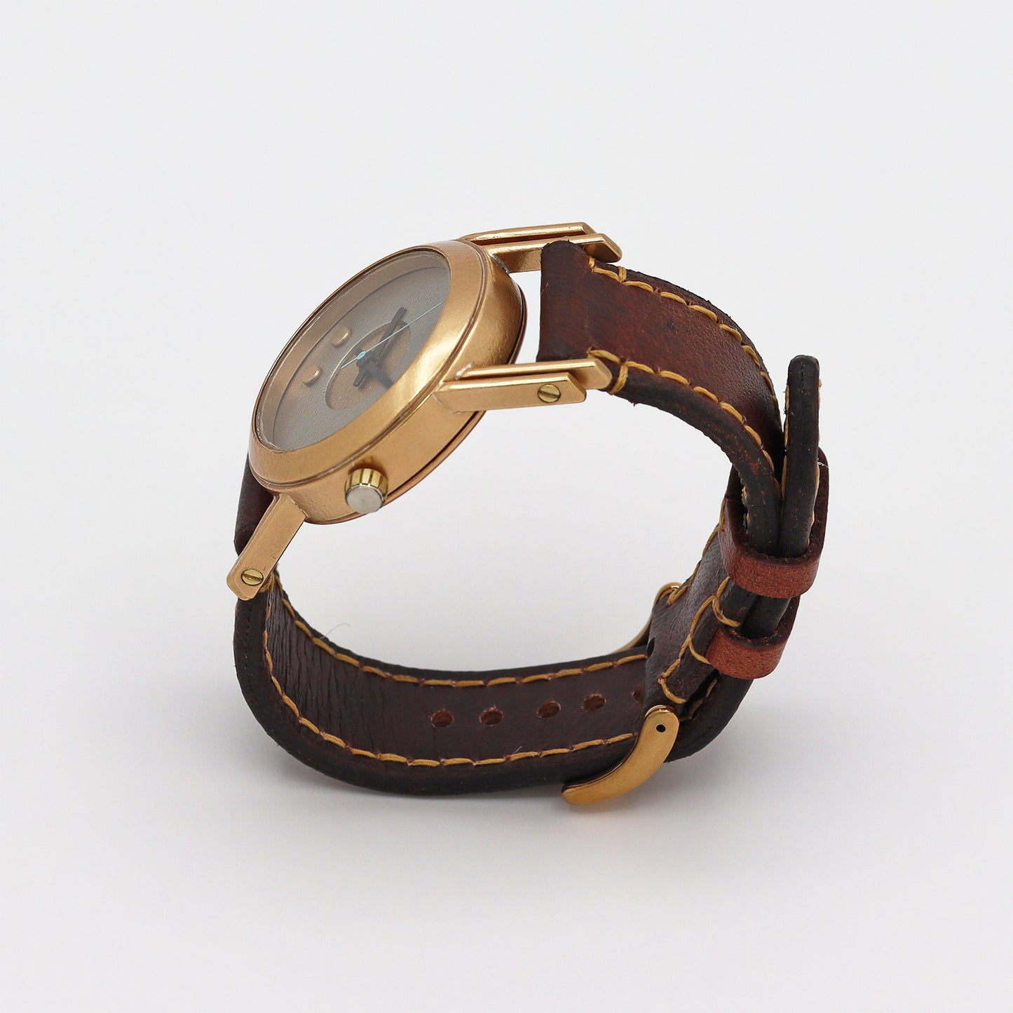 Retro futuristic wristwatch with brown leather strap and bronze casing on a white background