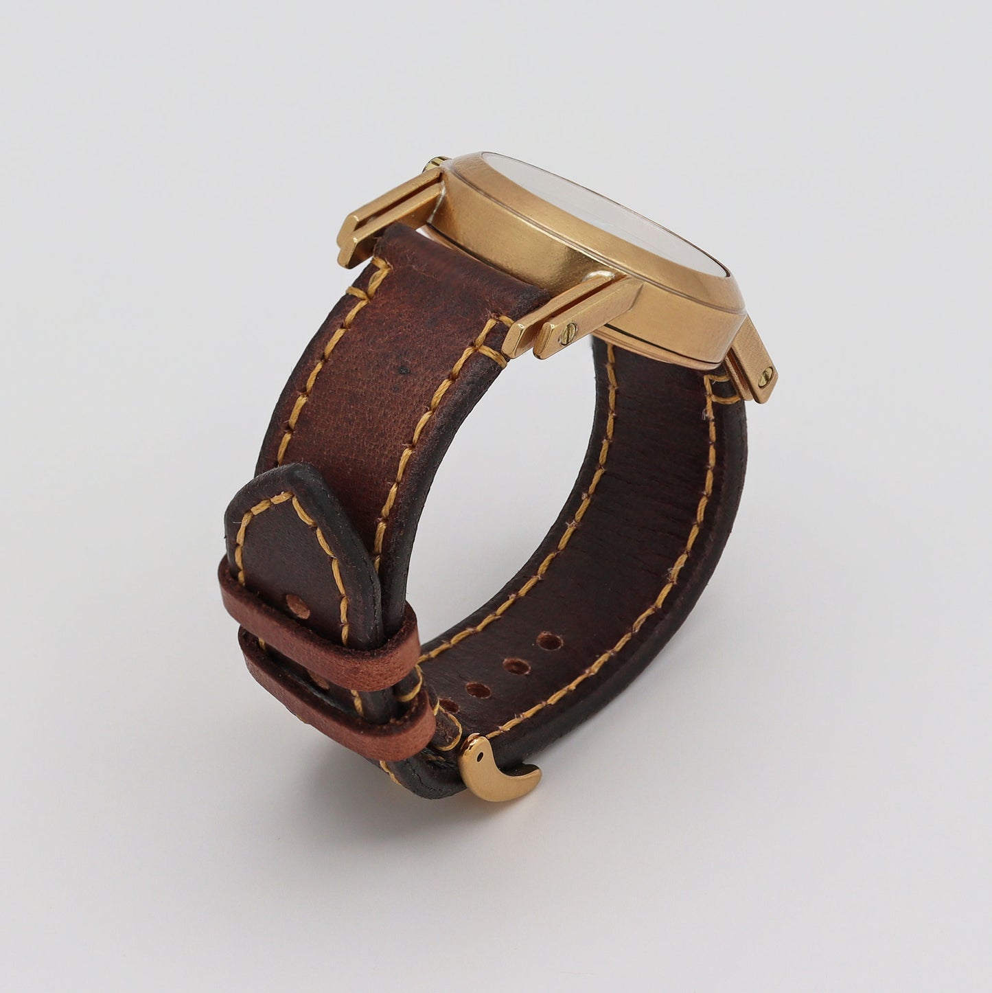 Retro futuristic wristwatch with brown leather strap and bronze casing on a white background
