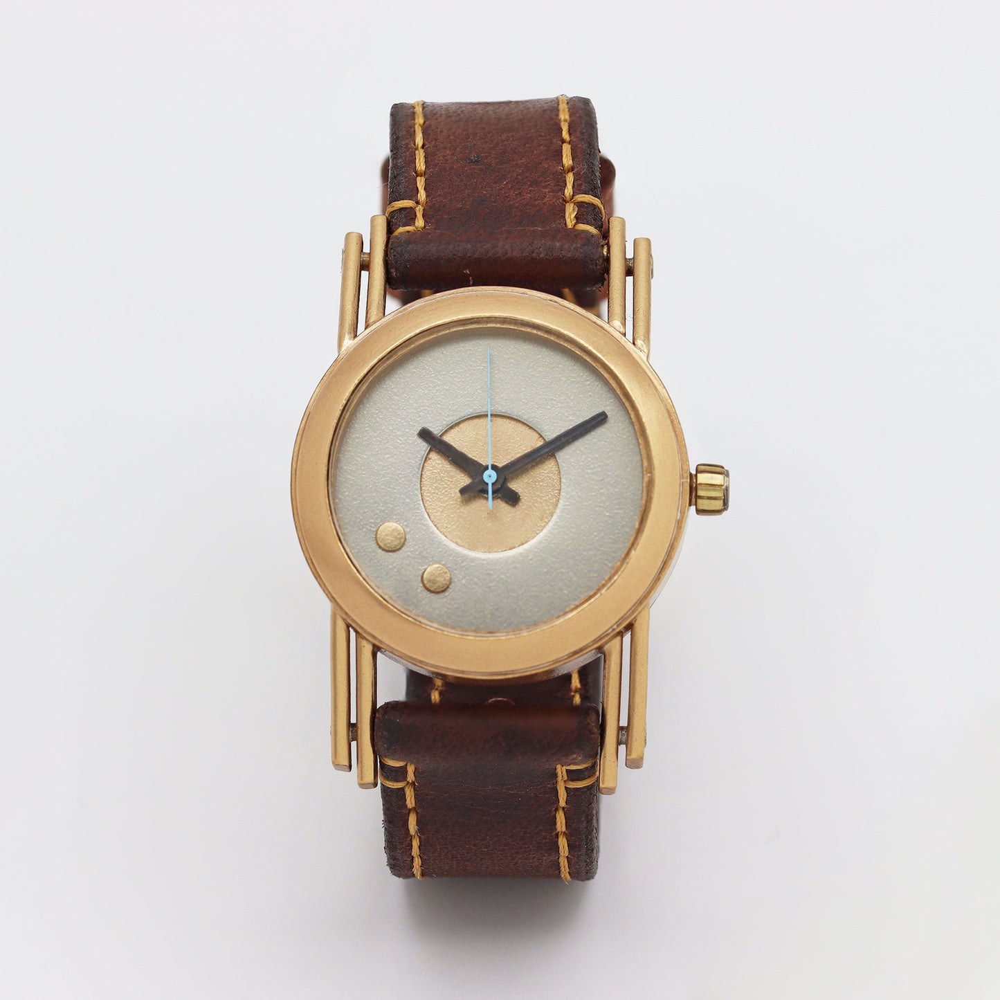Retro futuristic wristwatch with brown leather strap and bronze casing on a white background