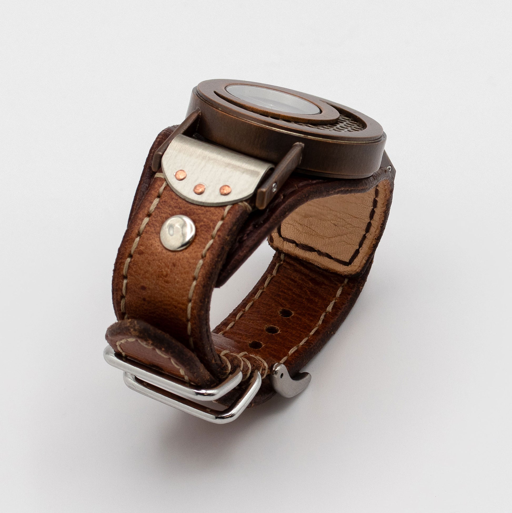 Brown leather watch strap with metal clasp on a white background
