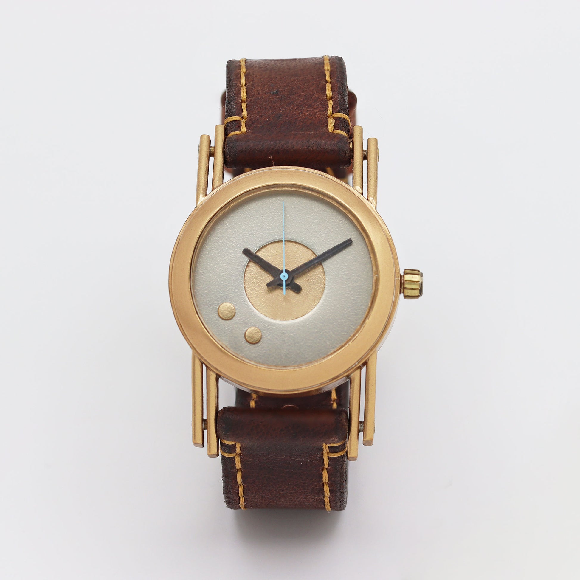 Retro futuristic wristwatch with brown leather strap and bronze casing on a white background