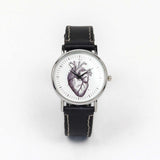 black leather wrist watch with an illustration of a heart on the dial